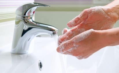 Person washing their hands in a sink