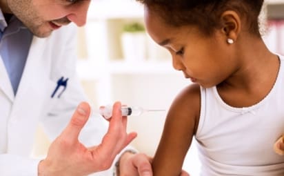 Doctor injecting child with vaccine