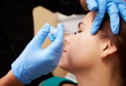 woman receiving botulinum toxin injection near her eye