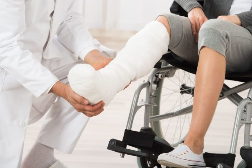 close-up of doctor looking at casted leg of a female patient