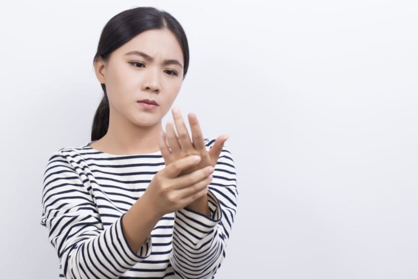 Woman massaging fingers and hand to increase blood flow