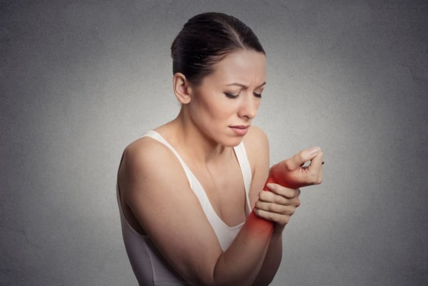 Woman holds her wrist in pain