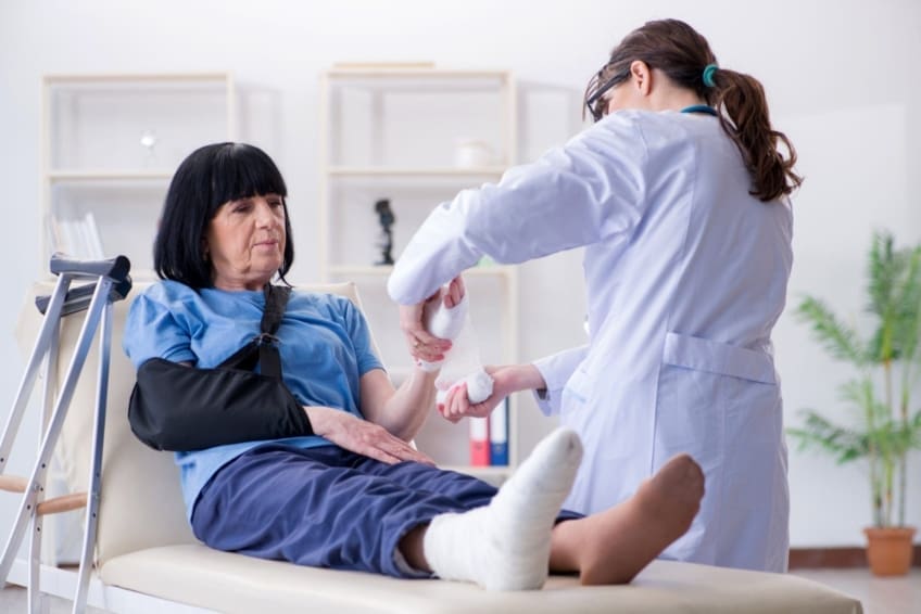 Doctor treating a senior woman who has possible bone fractures