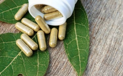 Plant sterols and stanols supplements in capsules spilling out from a white bottle