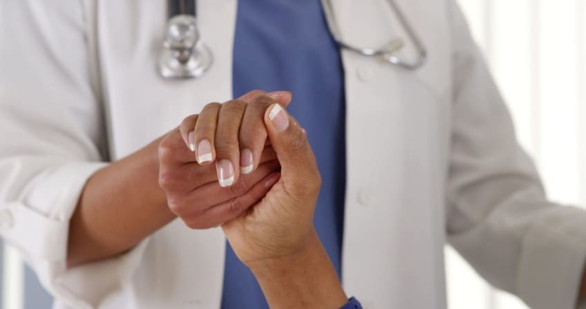 Close-up doctor holding female patient’s hand